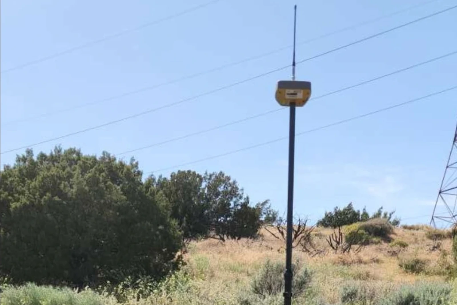 GNSS surveying receiver and tripod positioned in the field for land survey work